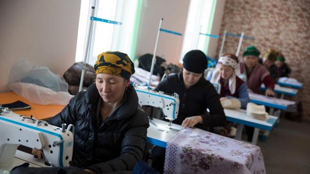 Workers operate sewing machines at Platinum Moynaq Cotton Cleaning Factory. Dust storms and the river bed poisoned due to agricultural chemical leaks for cotton production gave rise to a host of chronic and acute illness driving most residents away from Moynaq. (Taylor Weidman / Bloomberg) 