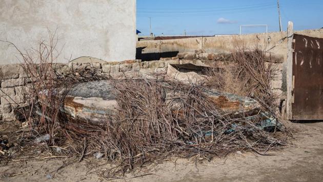 An abandoned boat sits in a street. Instead of the usual sights, tourists here are met with fleets of rusting shipwrecks and a museum devoted to all that once made Soviet era Moynaq proud --fishing nets, artefacts from the canning industry, more boats, and preserved fish. (Taylor Weidman / Bloomberg) 