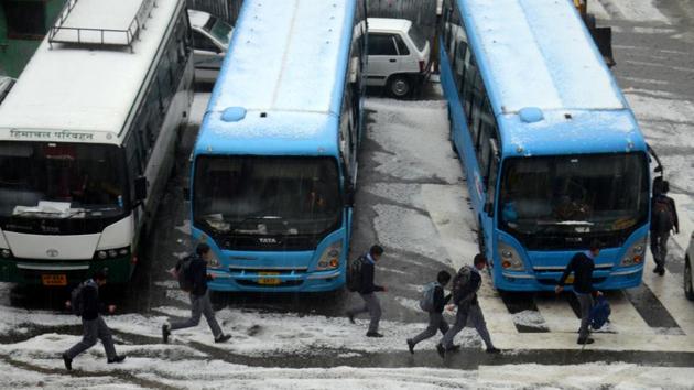Students walk towards their school buses during the hailstorm, at Lakkar Bazaar, Shimla on Tuesday. (Deepak Sansta/HT)