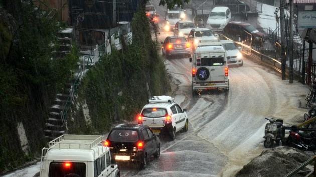 Vehicles moving slowly on the roads during hailstorm at Lakkar Bazaar, Shimla on Tuesday. (Deepak Sansta/HT)