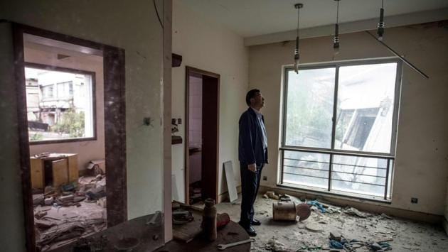 Chen Guoxing seen in a former teacher’s dormitory in Beichuan. For almost a decade, he has devoted himself to preserving a city of ghostly ruins, a massive open air memorial to the lives lost –including his son’s. He told AFP that the building was a time capsule, “family members had largely decided not to reclaim their possessions,” after residents died here. (Johannes Eisele / AFP) Chen Guoxing seen in a former teacher’s dormitory in Beichuan. For almost a decade, he has devoted himself to preserving a city of ghostly ruins, a massive open air memorial to the lives lost –including his son’s. He told AFP that the building was a time capsule, “family members had largely decided not to reclaim their possessions,” after residents died here. (Johannes Eisele / AFP)
