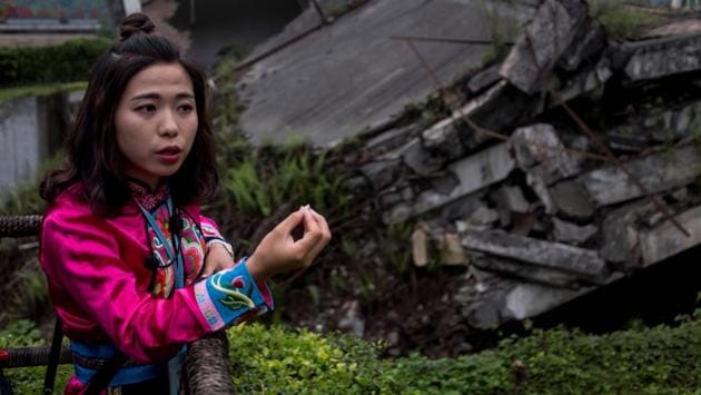 A 25-year-old guide, surnamed Ma standing next to a memorial site expressed concern about the region’s future. She and her co-workers spend their days standing on the highway, vying to flag down tourists on the way to the site. Ma said she would prefer not to be a guide but her family could not afford to send her to high school and this was the best job she could find. (Johannes Eisele / AFP) A 25-year-old guide, surnamed Ma standing next to a memorial site expressed concern about the region’s future. She and her co-workers spend their days standing on the highway, vying to flag down tourists on the way to the site. Ma said she would prefer not to be a guide but her family could not afford to send her to high school and this was the best job she could find. (Johannes Eisele / AFP)