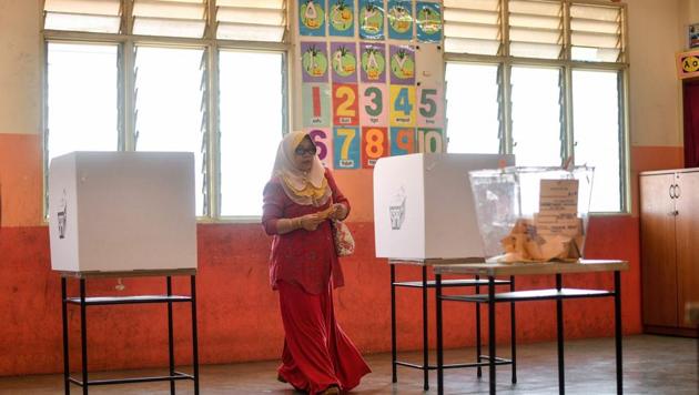 A Malaysian woman casts her vote during the 14th general election at a polling station in Kuala Lumpur on May 9, 2018.(AFP)