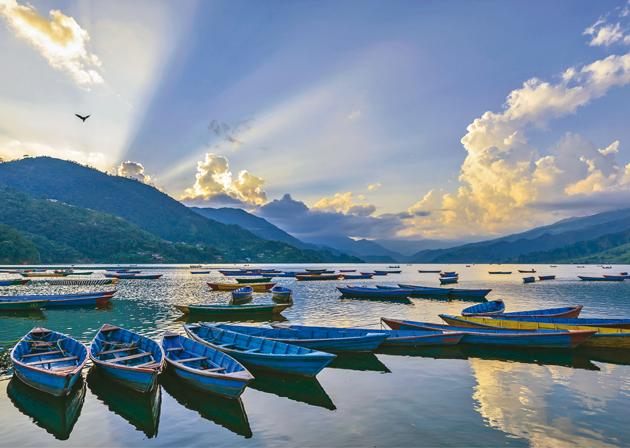 The rays of retreating sun on Phewa Lake dotted with country boats and pedal boats offer a magnificent view with hills in the backdrop(Shutterstock)