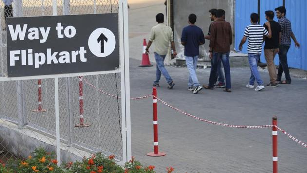People walk past a signage at the Flipkart headquarters in Bangalore, India.(AP Photo)