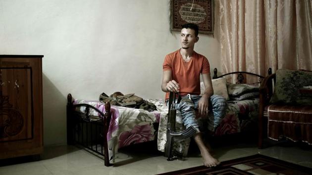 Osama Ahmed, now 21, holds his rifle at his home. Listed as terrorists because of their Yemini citizenship he said that they cannot even leave the country and look for other opportunities. On the day he left for battle Ahmed said his mother told him, “Son, I worry about you... But if every mother thinks this way, no one will go and fight for us... Do not leave your friends.” (Nariman El-Mofty / AP) 