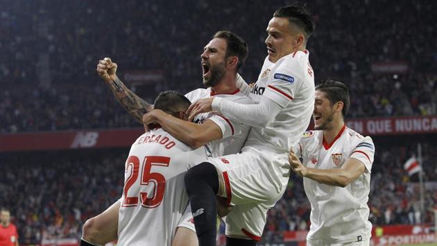 Sevilla's Mercado, left, celebrates with teammates Layun and Roque Mesa, right, after scoring against Real Madrid during their La Liga football match at the Sanchez Pizjuan stadium in Seville on Wednesday.(AP)