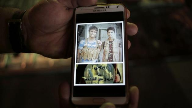 A photo displayed on the phone of 18-year-old Ahmed Saleh (L) with his friend reads, “marry me or I will go with Al Qaida.” For Ahmed, Saleh and their friends, it wasn’t a fight for President Hadi, it was for the south against the north. Southern Yemen was once independent and separatist sentiment remains powerful. (Nariman El-Mofty / AP) 