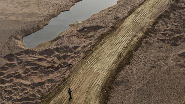 A man walks over truck tire tracks on Ken’s rich river bed in Madhya Pradesh.(HT File Photo)