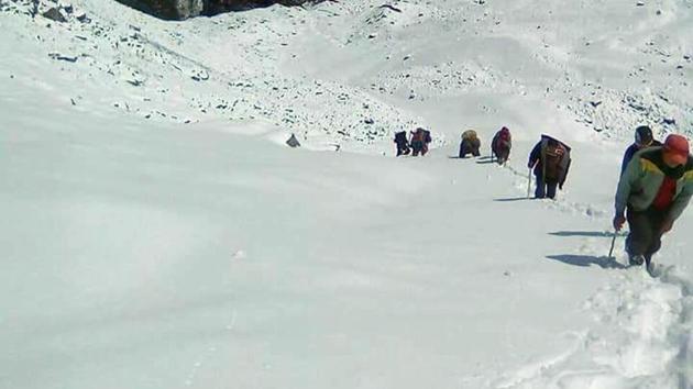 Villagers return from the base camp of Barmal peak in Chamoli district because of the heavy snowfall.(Sanjay Kunwar/HT Photo)