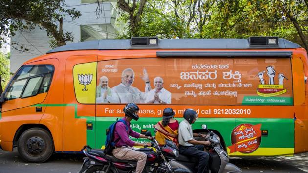 Motorcyclists ride past a bus featuring an image of Narendra Modi parked outside the Bharatiya Janata Party (BJP) office in Bengaluru. (Bloomberg) Motorcyclists ride past a bus featuring an image of Narendra Modi parked outside the Bharatiya Janata Party (BJP) office in Bengaluru. (Bloomberg)