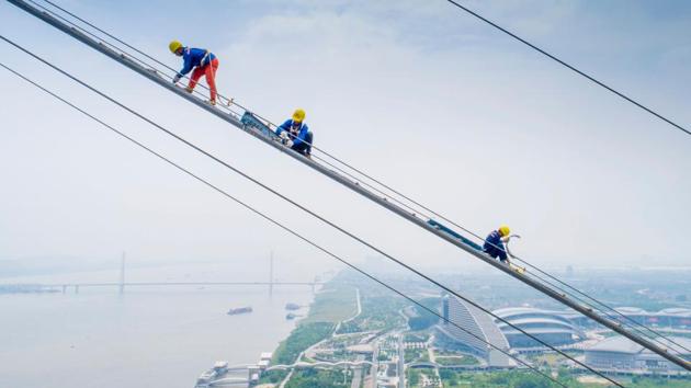 Workers labour on the construction of a double-deck suspension bridge crossing the Yangtze River in Wuhan in China's central Hubei province. (AFP Photo) Workers labour on the construction of a double-deck suspension bridge crossing the Yangtze River in Wuhan in China's central Hubei province. (AFP Photo)