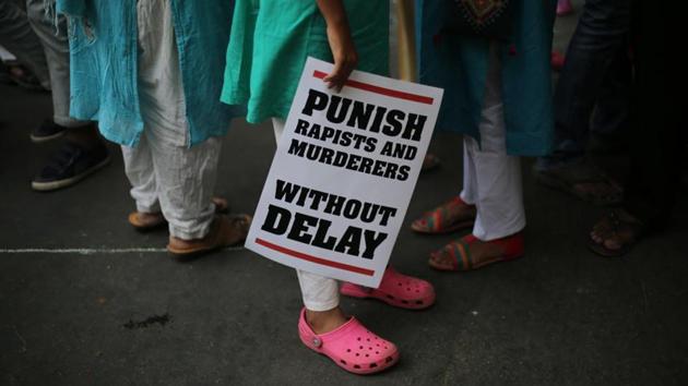 A protester stands with a placard during a protest in New Delhi.(AP Photo)