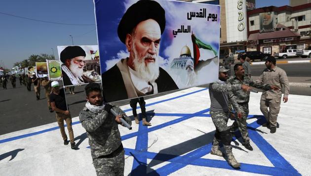 Supporters of Iraqi Hezbollah brigades march on a representation of an Israeli flag with a portrait of late Iranian leader Ayatollah Khomeini and Iran's supreme leader Ayatollah Ali Khamenei, in Baghdad, Iraq. (AP File Photo) Supporters of Iraqi Hezbollah brigades march on a representation of an Israeli flag with a portrait of late Iranian leader Ayatollah Khomeini and Iran's supreme leader Ayatollah Ali Khamenei, in Baghdad, Iraq. (AP File Photo)