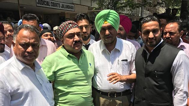 SHO Parminder Singh Bajwa (in green T-shirt) in police custody outside court in Jalandhar,on Friday.(HT Photo) SHO Parminder Singh Bajwa (in green T-shirt) in police custody outside court in Jalandhar,on Friday.(HT Photo)