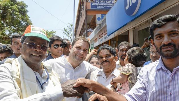 Congress President Rahul Gandhi (C) and Karnataka Chief Minister Siddaramaiah (L) shake hands with party supporters during a campaign in Honnavar on April 26, 2018. Releasing the party manifesto, Gandhi promised to create 10 million jobs in 5 years, give free smartphones to all college students between 18 and 23 years old and set apart 1.25 trillion rupees for irrigation projects. (PTI) Congress President Rahul Gandhi (C) and Karnataka Chief Minister Siddaramaiah (L) shake hands with party supporters during a campaign in Honnavar on April 26, 2018. Releasing the party manifesto, Gandhi promised to create 10 million jobs in 5 years, give free smartphones to all college students between 18 and 23 years old and set apart 1.25 trillion rupees for irrigation projects. (PTI)