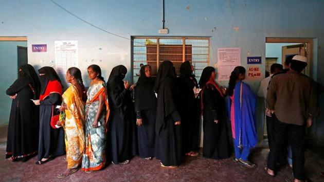 Voters wait in a queue to cast their ballot outside a polling station during Karnataka assembly elections in Bengaluru.(Reuters File Photo)