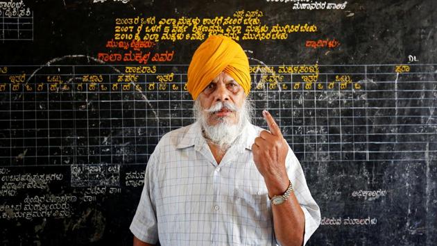 A man displays his finger marked with indelible ink as he poses for a photo outside a polling station. Opinion polls have forecast neither the BJP or Congress would emerge as a clear winner when Karnataka results are announced on May 15. Such an outcome could result in Janata Dal (Secular), taking the role of kingmaker in the 224-member state assembly. (Abhishek N. Chinnappa / REUTERS)