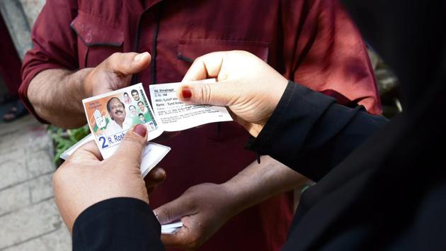 A voter tears off the part of slip containing the Congress party symbol at Abdul Bari's English Primary and High School in Bengaluru. The election in Karnataka is considered crucial for both the BJP and the Congress. The BJP is bidding to oust the Siddaramaiah government in Karnataka and is looking to come back to power in assembly elections with B.S. Yeddyurappa as its chief ministerial candidate. (Arijit Sen / HT Photo)