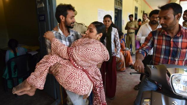 A man helps a physically disabled woman Husna after casting her vote during the assembly election in Bengaluru. For the Congress, a win in Karnataka would be a shot of confidence ahead of upcoming battles in Madhya Pradesh, Chhattisgarh and Rajasthan later in the year, apart from the general elections in 2019. (Arijit Sen / HT Photo)