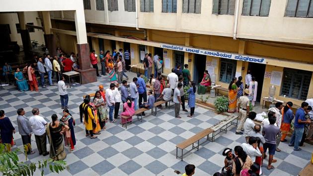 People wait in queues to cast their votes at a polling station during Karnataka assembly elections, in Bengaluru on May 12, 2018.(REUTERS)