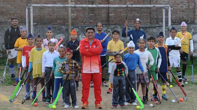Amritpal (centre), who works with Punjab State Electricity Board (PSEB) as a junior engineer and doubles up as a coach in the evening, is instrumental in the success of Kurali’s Gopal Hockey Academy, which has become a hub of hockey.(Photo: Ravi Kumar/Hindustan Times)