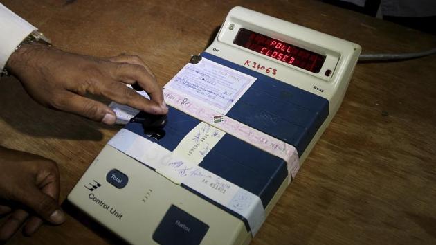 An election officer closes an electronic voting machine at the end of polls at a polling station in Bangalore on Saturday.(AP Photo)