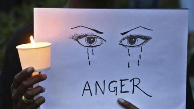 A woman holds a candle and placard seeking an end to sexual violence against women in Bangalore.(AP FIle Photo)