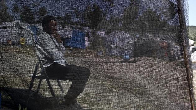 Hasan, from Deir ez-Zor in Syria, who arrived in Greece six months ago, sits behind the net of his tent at a makeshift camp outside the official camp of Moria. Amnesty observers recently visited island camps, and found hundreds of people sleeping in makeshift tents, children sleeping in unsupervised sites, and some resting in fields they say were overrun by rats. (Petros Giannakouris / AP) 