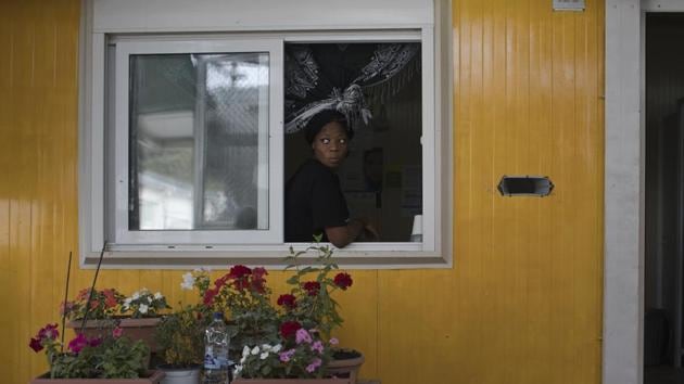 A woman looks out of a window of a prefabricated house in the sector of Moria Camp reserved to single women travelling alone. “We saw dozens of men with papers in their hand saying they were suffering from depression, anxiety disorders, and had suicidal dispositions; terrified women at risk of sexual violence in a European country that should be providing them with safety,” Spatharidou said. (Petros Giannakouris / AP) 