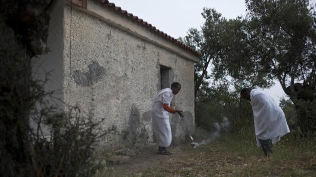 An Ethiopian Christian priest blesses another refugee during a Sunday Mass outside an orthodox church near Moria camp. The island containment policy started two years ago, when the massive flow of migrants was halted. Dimitris Vitsas, Greece’s migration minister, told parliament the new measures will need several months to take full effect. (Petros Giannakouris / AP) 