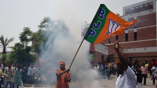 BJP supporters celebrate outside the party offices in New Delhi. Leaders in Delhi have sprung into action as both the Congress and the BJP strategize over garnering a majority. BJP’s JP Nadda, Dharmendra Pradhan and Prakash Javadekar are going to Bengaluru today. Meanwhile, a Congress delegation led by G Parameshwara, who had gone to the Governor’s House, was denied entry. (Burhaan Kinu / HT Photo)