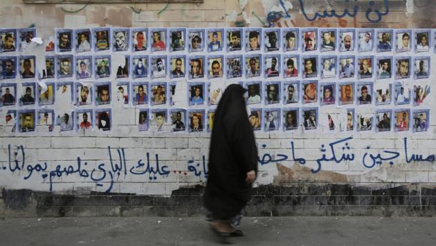 Bahraini woman walks past images of political prisoners plastered on a wall in Sanabis, Bahrain.(AP File Photo) Bahraini woman walks past images of political prisoners plastered on a wall in Sanabis, Bahrain.(AP File Photo)