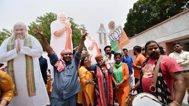 BJP workers with the cut-outs of PM Narendra Modi and party president Amit Shah on May 15, New Delhi(PTI)