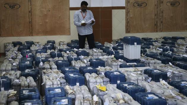 A polling official stands next to electronic voting machines at a vote counting center in Bengaluru, Karnataka. Counting of votes began at 8 am on Tuesday. (Aijaz Rahi / AP)