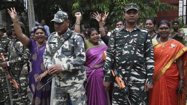 Paramilitary soldiers stand guard as supporters of Bharatiya Janata Party shout slogans outside a counting center in Bangalore. The elections in the southern state of Karnataka were held last Saturday. (Aijaz Rahi / AP)