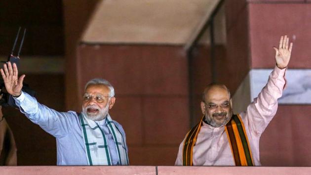 Prime Minister Narendra Modi and BJP President Amit Shah wave to party workers gathered at the party headquarters, after the Karnataka Assembly elections result 2018, in New Delhi, on Tuesday. (PTI Photo) Prime Minister Narendra Modi and BJP President Amit Shah wave to party workers gathered at the party headquarters, after the Karnataka Assembly elections result 2018, in New Delhi, on Tuesday. (PTI Photo)