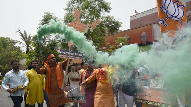 BJP workers celebrate as the party gained a significant lead in the Karnataka assembly election, outside the party headquarters in New Delhi on Tuesday. (Burhaan Kinu/HT Photo) BJP workers celebrate as the party gained a significant lead in the Karnataka assembly election, outside the party headquarters in New Delhi on Tuesday. (Burhaan Kinu/HT Photo)