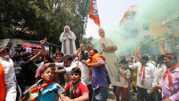 BJP supporters celebrate after learning of the initial poll results in the Karnataka state assembly elections on Tuesday.(REUTERS Photo)