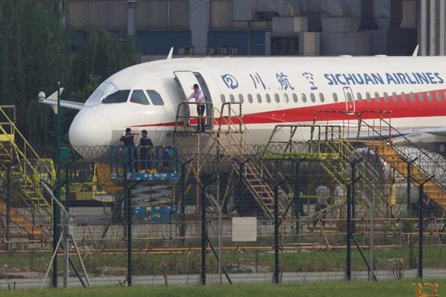 Workers inspect a Sichuan Airlines aircraft that made an emergency landing after a windshield on the cockpit broke off, at an airport in Chengdu, Sichuan province in China on Monday. (Reuters) Workers inspect a Sichuan Airlines aircraft that made an emergency landing after a windshield on the cockpit broke off, at an airport in Chengdu, Sichuan province in China on Monday. (Reuters)