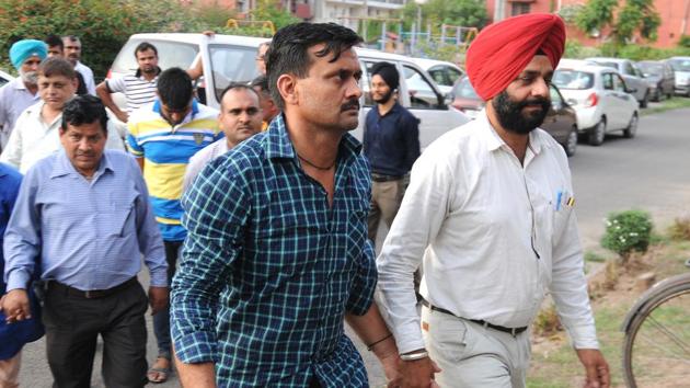 Sub-inspector Sewa Singh being taken to the duty magistrate in Sector 39, Chandigarh. Constable Sumit and middleman Ajay are the other two accused.(Ravi Kumar/HT)