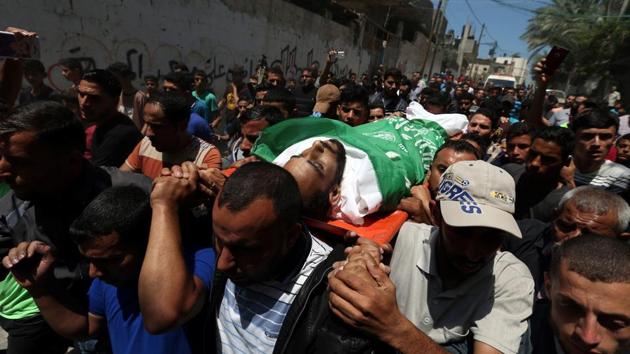 Mourners carry the body of a Palestinian, who was killed during a protest against US embassy move to Jerusalem at the Israel-Gaza border, during his funeral in the central Gaza Strip, May 15, 2018 (REUTERS) Mourners carry the body of a Palestinian, who was killed during a protest against US embassy move to Jerusalem at the Israel-Gaza border, during his funeral in the central Gaza Strip, May 15, 2018 (REUTERS)