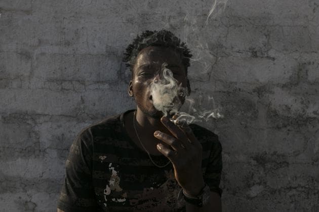Malawian migrant Jonas smokes marihuana on a rooftop. For now, tens of thousands of squatters, and others who say they pay nominal rents, are left in a filthy limbo without basic services and at the mercy of Johannesburg’s high rate of crime. Residents say they are disgusted by their living conditions. (Bram Janssen / AP) Malawian migrant Jonas smokes marihuana on a rooftop. For now, tens of thousands of squatters, and others who say they pay nominal rents, are left in a filthy limbo without basic services and at the mercy of Johannesburg’s high rate of crime. Residents say they are disgusted by their living conditions. (Bram Janssen / AP)