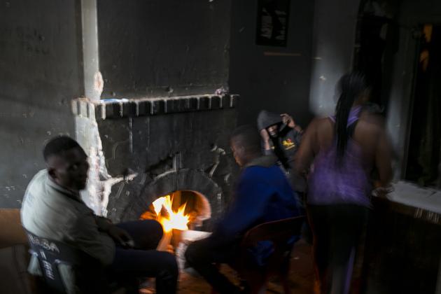 People warm themselves by a fire place in an abandoned building they occupy in downtown Johannesburg. Some squatters work as security guards, domestic workers and small traders in neighbourhoods nearby, while others are unemployed, hustle or turn to crime. (Bram Janssen / AP) People warm themselves by a fire place in an abandoned building they occupy in downtown Johannesburg. Some squatters work as security guards, domestic workers and small traders in neighbourhoods nearby, while others are unemployed, hustle or turn to crime. (Bram Janssen / AP)