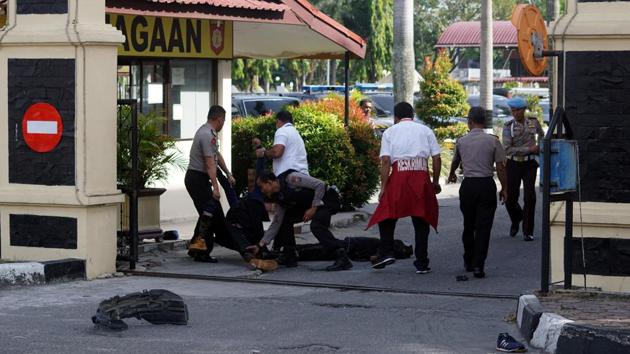 Police remove the bodies of attackers who were shot and killed at the entrance of a police station in Pekanbaru, Indonesia.(Antara Foto/ Retmon/ via Reuters)