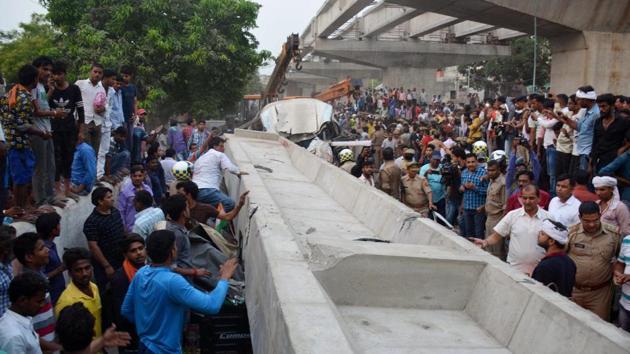 Locals and rescue teams gather near crushed vehicles after a portion of an under-construction flyover collapsed in Varanasi on Tuesday.(PTI Photo)