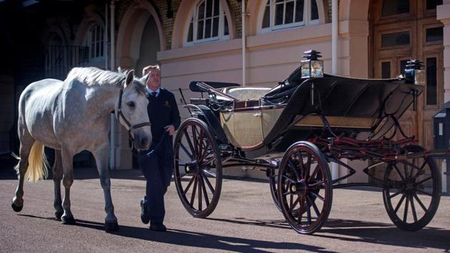 Philip Barnard-Brown, Senior Coachman at the Buckingham Palace Mews, leads a Windsor Grey, one of the horses that will pull the carriage at today’s wedding, past the Ascot Landau carriage which is the centre piece of the celebratory procession around Windsor. (Victoria Jones / REUTERS)
