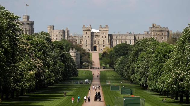 People walk along the Long Walk leading up to Windsor Castle. The Long Walk will be lined with well-wishers waiting to greet the royal couple as they pass by heading back to the castle at the end of the carriage procession after the ceremony. (Daniel Leal-Olivas / AFP)