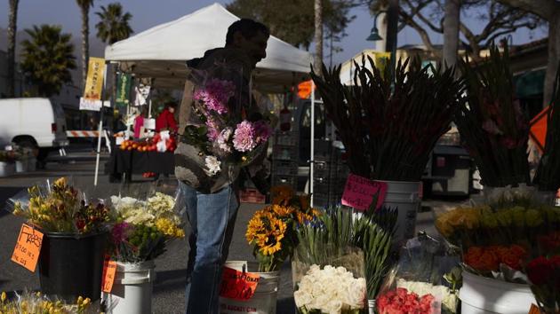 A man buys locally grown flowers at a farmers’ market in Carpinteria. The result is a large number of licenses but small total acreage. Only about 200 acres of the county’s farmland is devoted to marijuana, compared with tens of thousands sown with strawberries and vegetables, said Dennis Bozanich, who oversees the county’s marijuana planning. (Jae C. Hong / AP) A man buys locally grown flowers at a farmers’ market in Carpinteria. The result is a large number of licenses but small total acreage. Only about 200 acres of the county’s farmland is devoted to marijuana, compared with tens of thousands sown with strawberries and vegetables, said Dennis Bozanich, who oversees the county’s marijuana planning. (Jae C. Hong / AP)