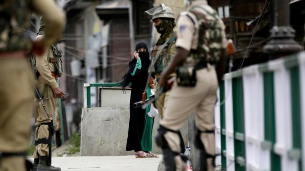 A Kashmiri woman looks at paramilitary soldiers standing guard on the first day of the holy month of Ramadan in on May 17.(AP Photo)